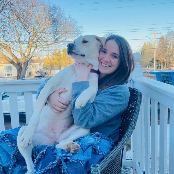 Emilie Boucher holding her dog on a deck