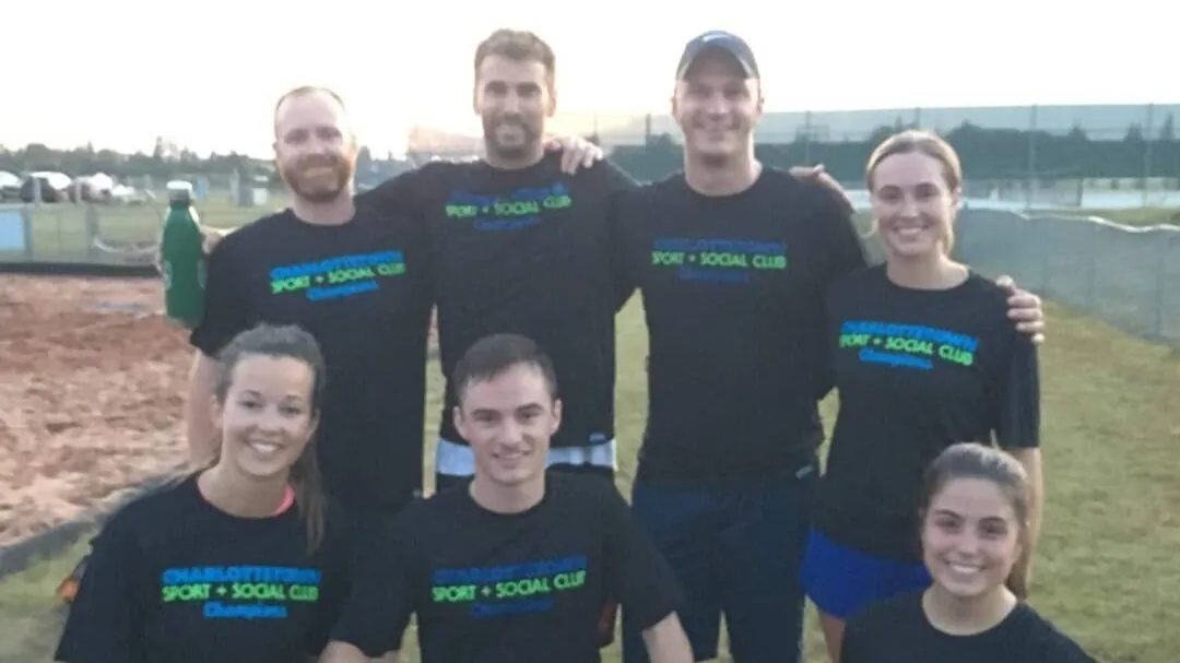 A CSSC team in club shirts outdoors at dusk